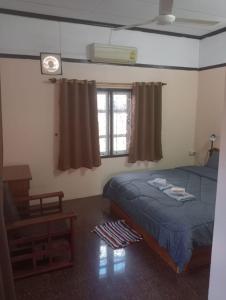 巴色Bolaven trail guesthouse的一间卧室配有一张床、一张桌子和一个窗户。