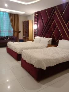 伊斯兰堡PAK HOTEL Islamabad的酒店客房,设有两张床和一张沙发