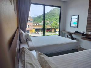 拉廊TOBEDzZ HOTEL的一间卧室设有两张床和大窗户