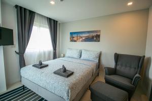 Ban Tha FatMantra Beach Condominium Suite 2 - Mae Phim的一间小卧室,配有一张床和一把椅子