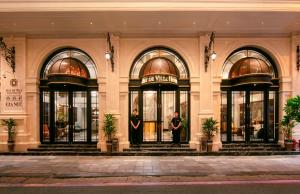 河内May De Ville Luxury Hotel & Spa的两个人站在大楼门口