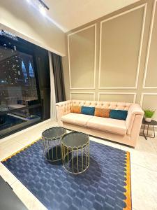 吉隆坡Axon Residence By Leo Suites的客厅配有沙发和两把椅子