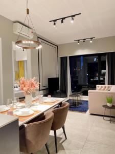 吉隆坡Axon Residence By Leo Suites的用餐室以及带桌椅的起居室。