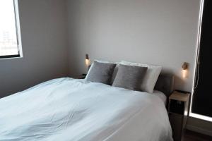 大村市【 STAY Chill ~omura~】長崎空港から車で10分！的卧室配有白色的床和2个枕头