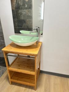 勒唐蓬La Maison Verte的浴室设有木制梳妆台上的绿色碗水槽