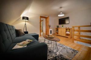 卡罗林卡Karolinka Holiday Homes的客厅配有蓝色的沙发和电视