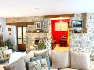 多尔多尼河畔博利厄Dordogne Farmhouse的带沙发和石墙的客厅