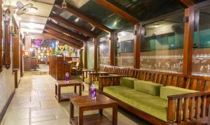 浦那Treebo Trend Bhairavee - Baner的一间设有绿沙发和桌子的餐厅