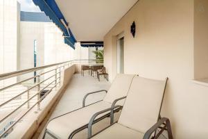 马贝拉3 Room LUX Apt Puerto Banus-Terrace 5 min to beach-Pool Now Open的阳台配有2把白色椅子和桌子