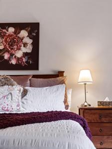 Cowaramup诺贝尔葡萄宾客酒店的卧室配有一张挂有花卉画的床铺。