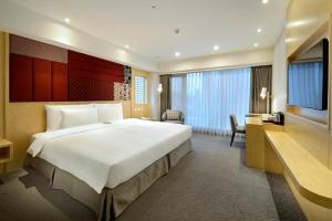 台北松哖酒店的酒店客房设有一张大床和一张书桌。