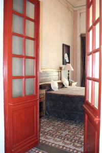 普埃布拉卡萨德拉帕尔马精品酒店的一间卧室设有一张床和一扇红色的门