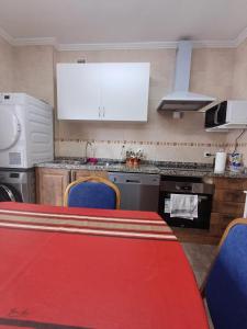 米耶雷斯Hostal的厨房配有红色的桌子和蓝色的椅子