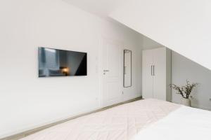 特希尔Küsten Suite de See - Suite 4 seitliche Deichlage, Balkon, 89qm的白色的房间,墙上配有电视