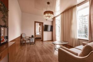 茨卡尔图博Park Hotel Tskaltubo - Balneo Resort的客厅配有沙发和桌子