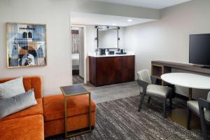 奥兰多Embassy Suites by Hilton Orlando North的客厅配有沙发和桌子