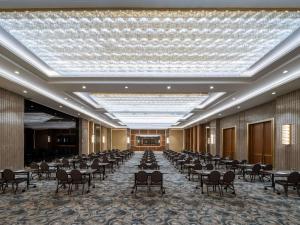 伊斯坦布尔Sofitel Istanbul Taksim的一个带桌椅的大型宴会厅