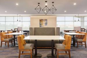 劳雷尔山La Quinta Inn & Suites by Wyndham Mount Laurel Moorestown的餐厅设有桌椅和窗户。