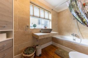 诺里奇58D Earlham Road的一间带水槽和浴缸的浴室以及窗户。