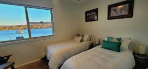SaratogaCentral Coast Jetty House的一间卧室设有两张床和窗户。