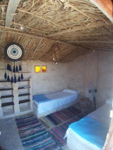 锡瓦M Biama Island的客房设有两张床和一个带风扇的天花板。