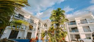 南迪Ocean Breeze Apartment的一座白色的建筑,前面有棕榈树