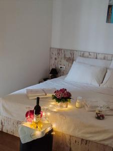丘普里亚Cruiser restoran的一张带蜡烛的床和一瓶葡萄酒及鲜花