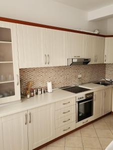 都拉斯Durres Center的厨房配有白色橱柜和炉灶烤箱。