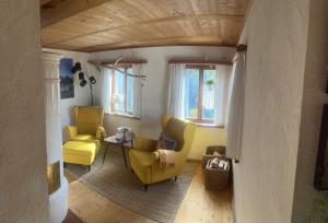 罗滕堡Ferienhaus Kobolzeller Schlößchen a.d.Weinsteige的客厅配有2把黄色椅子和桌子