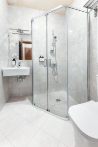 茨卡尔图博Park Hotel Tskaltubo - Balneo Resort的一间带玻璃淋浴和水槽的浴室