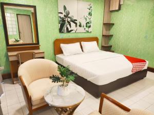 曼谷OYO 75446 Travis Inthamara 49的卧室配有一张床和一张桌子及椅子