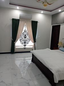伊斯兰堡Edge of Islamabad Entrance的一间卧室设有一张床和一个大窗户