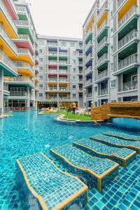 芭东海滩Bauman Residence Patong, Phuket的公寓大楼前的游泳池设有躺椅