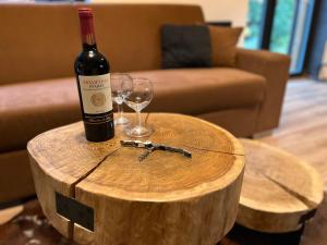 弗尔赫拉比Apartmán Herlíkovice 303的木桌上的一瓶葡萄酒和一杯葡萄酒