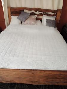 纳纽基Black gate的一张带白色床单和枕头的木床