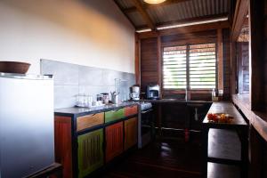 阿姆巴托洛阿卡香蕉月亮公寓的厨房配有色彩缤纷的橱柜和冰箱。