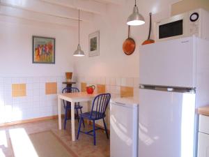 Saint-Julien-la-GenèteHoliday home in Saint-Julien-La-Genête的厨房配有桌子和冰箱
