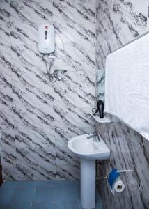 科托努Magnifique Appartement - Cotonou - Avotrou Apkapka的浴室配有白色水槽和石墙