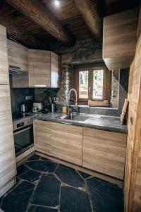 圣拉里苏朗La grange du hameau的厨房配有木制橱柜、水槽和窗户。