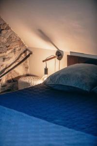 圣拉里苏朗La grange du hameau的一间卧室配有一张带蓝色毯子和灯的床。