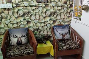 新德里La Floraison - Solo/Couple-Hauz khas/AIIMS/IIT的两把椅子,墙上挂着一幅鹿的照片
