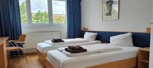 柏林豪斯尼德菲尔德HW酒店 的两张位于酒店客房的床,配有毛巾