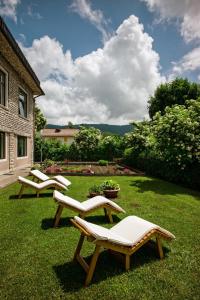 福尔加里亚意大利安蒂科阿尔贝哥斯黛拉酒店的两把躺椅坐在院子里的草地上