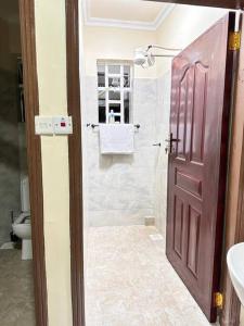基塔莱Luxurious 2 bedroom penthouse-Fully Furnished的带淋浴的浴室和棕色的门