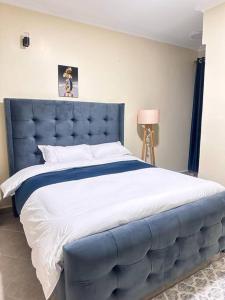 基塔莱Luxurious 2 bedroom penthouse-Fully Furnished的卧室内的一张带蓝色床头板的大床