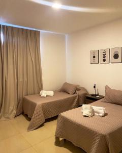 科连特斯Dptos Corrientes con cochera的酒店客房设有两张床和窗户。