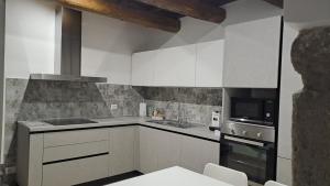 维托尔基亚诺Alloggio turistico Pietra Viva的厨房配有白色橱柜和炉灶烤箱。