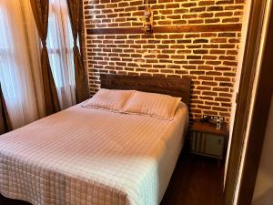 迪亚巴克尔Karga Butik Otel的卧室内的一张床位,卧室设有砖墙