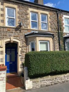 卡迪夫Cardiff - Home from Home的一座砖房,有蓝色的门和树 ⁇ 