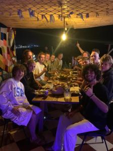 塔哈佐特sunny wave taghazout SURF & YOGA的一群人晚上坐在桌子旁